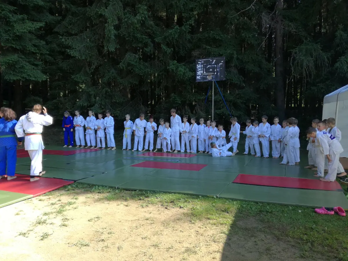 Letní soustředění v lese — kids v bílém judogi v sevřené formaci
